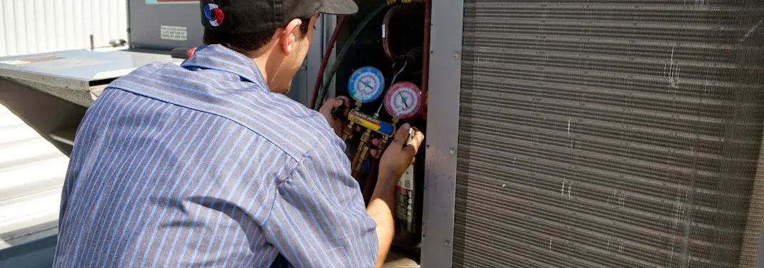 HVAC technician servicing a condenser unit in Peru