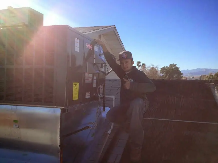 HVAC technician performing AC Tune-Up on a rooftop unit in Peru